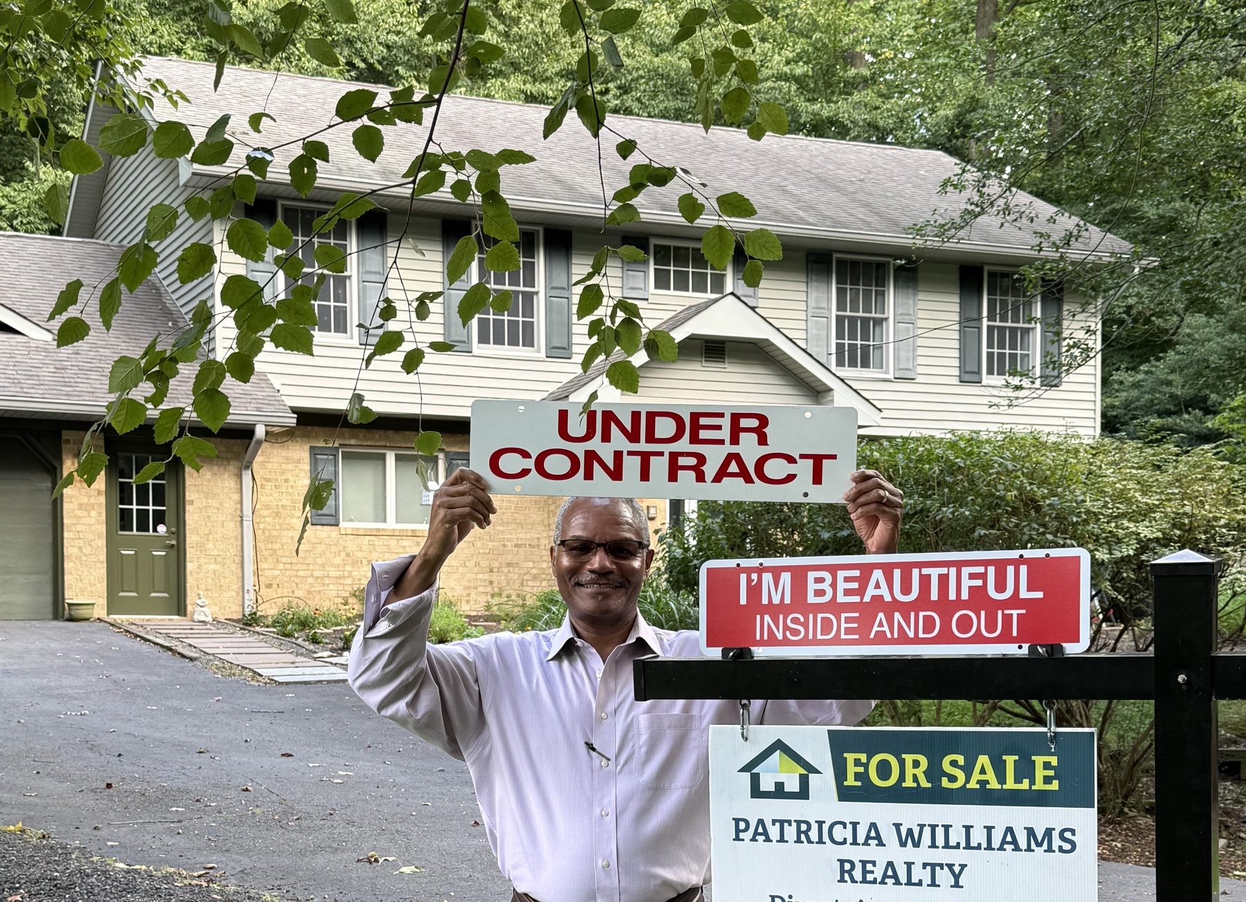 Chris Streeter holding an Under Contract sign in front of a client's home